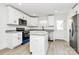 Bright kitchen features white cabinets, stainless appliances, a kitchen island, and granite countertops at 624 W Kerr St, Salisbury, NC 28144