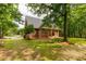 Brick home with a well-maintained yard, featuring a covered patio and lush greenery, perfect for outdoor living at 728 Palmers Pl, Rock Hill, SC 29730