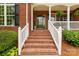 Inviting front porch with brick steps, white railings, and decorative plants offering a warm welcome at 728 Palmers Pl, Rock Hill, SC 29730