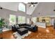 Sunlit living room with vaulted ceilings, hardwood floors, and a seamless transition to the adjacent kitchen at 728 Palmers Pl, Rock Hill, SC 29730