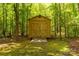 Wooden storage shed in a wooded backyard, offering practical storage space and blending with the natural surroundings at 728 Palmers Pl, Rock Hill, SC 29730