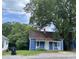 Charming blue home featuring a cozy front porch and a well-maintained gravel yard at 739 Old Charlotte Sw Rd, Concord, NC 28027