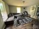 Spacious living room featuring a large gray sectional sofa, dark floors, and bright natural light at 739 Old Charlotte Sw Rd, Concord, NC 28027