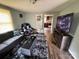 Living room with a gray sectional sofa, dark wood-look floors, large tv, and view into kitchen at 739 Old Charlotte Sw Rd, Concord, NC 28027