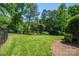 Well-manicured backyard with lush lawn, landscaping, and fence at 8028 Water View Dr, Belmont, NC 28012