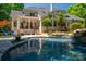 Beautiful backyard oasis with a sparkling pool, stone waterfall, and expertly manicured landscaping at 8028 Water View Dr, Belmont, NC 28012