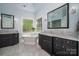 Luxurious bathroom with a soaking tub, dual vanities, and elegant lighting at 8028 Water View Dr, Belmont, NC 28012