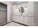 Bathroom featuring custom vanity cabinets, a round mirror, and decorative tile backsplash at 8028 Water View Dr, Belmont, NC 28012