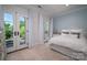 Bright bedroom with white bedding and pillows, with French doors leading to the outdoors at 8028 Water View Dr, Belmont, NC 28012