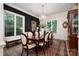 Formal dining room with wainscoting, chandelier, and natural light from large windows at 8028 Water View Dr, Belmont, NC 28012