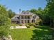 Stately brick home boasting a manicured lawn, mature trees, and inviting front columns at 8028 Water View Dr, Belmont, NC 28012