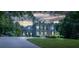 Elegant home exterior at twilight featuring a well-manicured lawn and lighted facade at 8028 Water View Dr, Belmont, NC 28012
