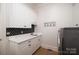 Functional laundry room with a sink, storage cabinets, and a stylish backsplash at 8028 Water View Dr, Belmont, NC 28012