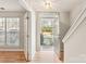 Bright foyer with hardwood floors, features an open doorway and sunlit window, creating a welcoming entry at 8177 Millwright Ln, Charlotte, NC 28277