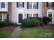 Close-up showcasing the entrance of a townhome with a well-kept lawn, neat bushes, and a paved walkway for a welcoming approach at 8177 Millwright Ln, Charlotte, NC 28277