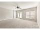 Bright living room with plush carpet, neutral walls, ceiling fan, and glass doors to a deck at 8177 Millwright Ln, Charlotte, NC 28277