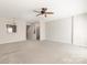 Open-concept living room features plush carpet, neutral walls, and a view into another living space at 8177 Millwright Ln, Charlotte, NC 28277
