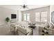 Bright living room featuring plush seating, a modern ceiling fan, and sun-drenched windows with french doors at 8177 Millwright Ln, Charlotte, NC 28277