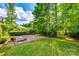 Picturesque backyard with an expansive lawn, mature trees, and a brick patio, perfect for outdoor gatherings at 8239 Victoria Lake Dr, Waxhaw, NC 28173