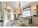 Elegant bathroom featuring a stone-clad tub, chandelier, and marble countertops at 8239 Victoria Lake Dr, Waxhaw, NC 28173