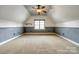 Upstairs bonus room with carpet and wainscotting under a ceiling with a fan and dormer window at 8239 Victoria Lake Dr, Waxhaw, NC 28173