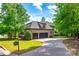 View of the brick home with a three-car garage and large driveway at 8239 Victoria Lake Dr, Waxhaw, NC 28173