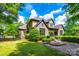 Charming stone and stucco home with a well-manicured lawn and mature landscaping at 8239 Victoria Lake Dr, Waxhaw, NC 28173