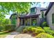 Charming home showcasing a stone and brick facade, a covered porch, and professionally landscaped front yard at 8239 Victoria Lake Dr, Waxhaw, NC 28173
