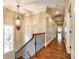 Elegant hallway with hardwood floors, iron railing, and decorative lighting at 8239 Victoria Lake Dr, Waxhaw, NC 28173