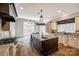 Bright kitchen features an oversized island, stainless steel appliances, dark wood floors, and light countertops at 8239 Victoria Lake Dr, Waxhaw, NC 28173