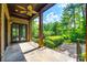 Covered patio with stone flooring and a ceiling fan offering views of the landscaped backyard at 8239 Victoria Lake Dr, Waxhaw, NC 28173