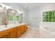 Bathroom featuring a double sink vanity, garden tub, and large window at 9066 Tulagi Ct, Tega Cay, SC 29708