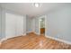 Bedroom featuring hardwood floors, fresh paint, a closet and access to an en suite bathroom at 9066 Tulagi Ct, Tega Cay, SC 29708