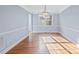 Empty dining room with hardwood floors, natural light from the window, and wainscoting at 9066 Tulagi Ct, Tega Cay, SC 29708