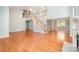Large open-plan living room with a staircase, chandelier, fireplace, and hardwood flooring at 9066 Tulagi Ct, Tega Cay, SC 29708