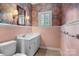 Cozy powder room with vanity, mirror, and decorative wallpaper at 920 Queens Rd, Charlotte, NC 28207