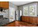 Kitchen featuring wood cabinets, granite counters, stainless appliances, hardwood floors, and natural light at 920 Queens Rd, Charlotte, NC 28207