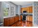 This kitchen has wood cabinets, granite countertops, stainless appliances, hardwood floors, and natural light at 920 Queens Rd, Charlotte, NC 28207