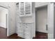 Built-in white hutch with glass door cabinets and drawers in room with hardwood floors at 920 Queens Rd, Charlotte, NC 28207