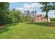 Expansive backyard view with lush green lawn and mature trees in the background at 1004 Princesa Dr, Matthews, NC 28104
