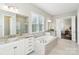 Bright bathroom featuring a soaking tub, double vanity with granite countertops, and a separate shower at 1004 Princesa Dr, Matthews, NC 28104