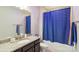 A bathroom featuring a tub-shower combo with a decorative blue shower curtain, vanity, and granite countertops at 1004 Princesa Dr, Matthews, NC 28104