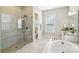 Luxurious bathroom with a glass-enclosed shower, soaking tub, and elegant vanity at 1004 Princesa Dr, Matthews, NC 28104
