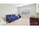 Cozy bedroom with a twin bed, soft carpet, a window with natural light, and neutral wall color at 1004 Princesa Dr, Matthews, NC 28104