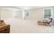 Spacious bonus room with neutral walls, plush carpet, large windows, and a comfortable seating area at 1004 Princesa Dr, Matthews, NC 28104