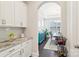 Butler's pantry with marble countertops, white cabinets, and a view into the dining room at 1004 Princesa Dr, Matthews, NC 28104