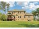 Back exterior view of the home showcasing a deck, well-maintained lawn, and classic brick facade at 1004 Princesa Dr, Matthews, NC 28104