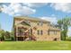 Back exterior view of the home showcasing a deck, well-maintained lawn, and classic brick facade at 1004 Princesa Dr, Matthews, NC 28104