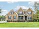 Beautiful two-story brick home with a stone entryway and well-maintained landscaping at 1004 Princesa Dr, Matthews, NC 28104