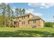 Back exterior view of the home showcasing a deck, well-maintained lawn, and classic brick facade at 1004 Princesa Dr, Matthews, NC 28104
